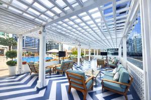 a white pergola on a balcony with chairs and tables at TIME Oak Hotel & Suites in Dubai