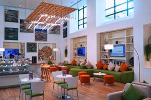 a lobby with couches and tables and chairs at TIME Oak Hotel & Suites in Dubai