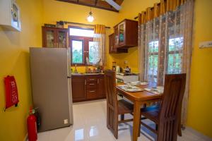 a kitchen with a table and chairs and a refrigerator at Serene Vista Villa, formerly Bungalows in Hikkaduwa +42 photos