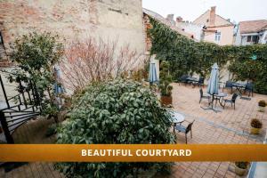 an outdoor patio with tables and umbrellas and plants at Rosen Villa Sibiu in Sibiu