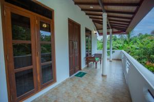 a porch of a house with a door and a chair at Serene Vista Villa, formerly Bungalows in Hikkaduwa