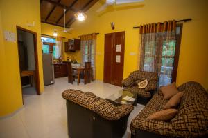 a living room with two couches and a kitchen at Serene Vista Villa, formerly Bungalows in Hikkaduwa
