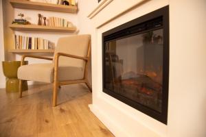 a living room with a fireplace and a chair at Gemütliches Apartment mit Garten nahe Köln in Frechen