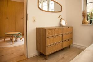 a bedroom with a dresser and a mirror on a wall at Gemütliches Apartment mit Garten nahe Köln in Frechen