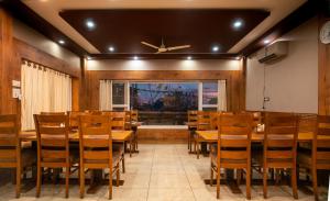 a dining room with wooden tables and chairs at Hotel Buddha House Himalayan Brothers in Dharamshala