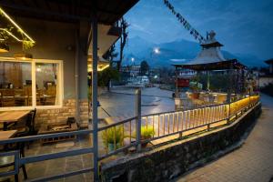 a fence next to a building with a restaurant at Hotel Buddha House Himalayan Brothers in Dharamshala