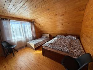 an attic bedroom with two beds and a window at Junkuri Holiday House 9 Beds up to 20 Guests in Jeroškina