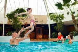 a young boy jumping into the water in a swimming pool at Center Parcs Eifel Mosel Nürburgring in Gunderath