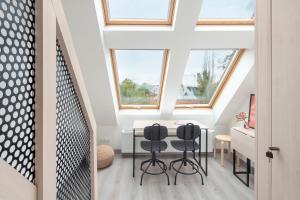a room with a table and two black chairs at Lofty Kampus Garnizon in Gdańsk