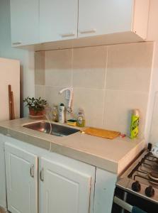 a kitchen counter with a sink and a stove at Departamento J&J 2 in Aristóbulo del Valle