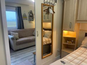 a bedroom with a couch and a mirror in a room at Field View 162a fifth Ave in Bridlington +46 photos