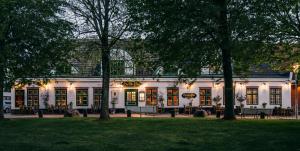 a large white building with trees in front of it at Boutique-Hotel Zur alten Post in Büsum