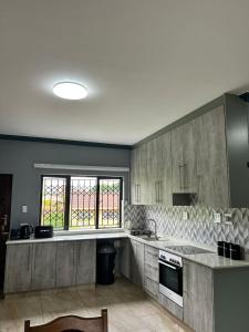 a large kitchen with gray cabinets and a window at Crompton Gardens 786 in Durban +13 photos