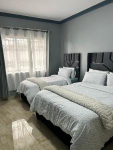 three beds in a bedroom with white walls at Crompton Gardens 786 in Durban