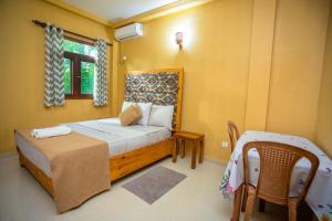 a bedroom with a bed and a table and a window at Serene Vista Villa, formerly Bungalows in Hikkaduwa