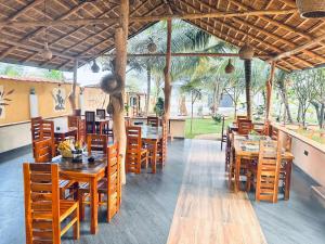 a dining room with wooden tables and chairs at GreenKey Hotel & Resturent in Tanamalwila