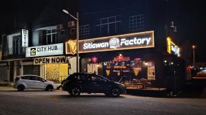 a car parked in front of a store at night at City Hub Hotel Sitiawan in Sitiawan