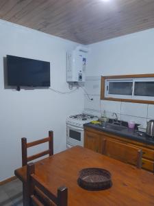 a kitchen with a table and a sink and a stove at Casita Rosa II in San José
