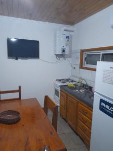 a kitchen with a table and a stove top oven at Casita Rosa II in San José +18 photos