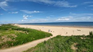 a beach with people on the sand and the ocean at Field View 162a fifth Ave in Bridlington