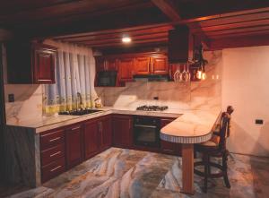 a kitchen with wooden cabinets and a table in it at Calle del Tigre Chalet in Sabana Redonda