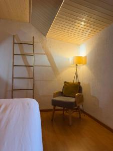 a room with a chair and a lamp and a ladder at La ruche in Bourg-de-Péage