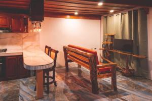 a kitchen with a table and a bench and a counter at Calle del Tigre Chalet in Sabana Redonda