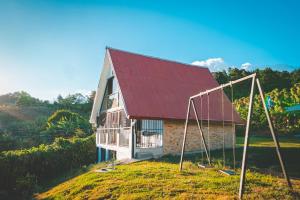 a house with a red roof and two swings at Calle del Tigre Chalet in Sabana Redonda +4 photos