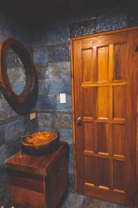 a bathroom with a wooden toilet and a mirror at Calle del Tigre Chalet in Sabana Redonda