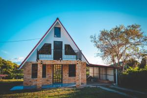a house with a gambrel roof with a balcony at Calle del Tigre Chalet in Sabana Redonda