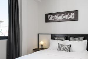 a bedroom with a white bed and a window at CASA BLANCA Dusit in Dusit