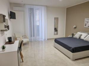 a bedroom with a bed and a living room at ASTRA Guest House in Taranto
