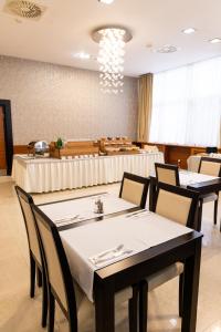a dining room with tables and chairs and a room with at Garni Hotel Nevski in Belgrade