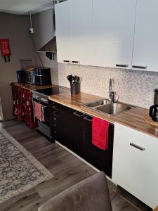 a kitchen with white cabinets and a sink at MarrasVilla in Marrasjärvi +4 photos