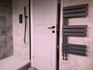a white door in a bathroom with a shower at Wildoaks in Northwood +4 photos