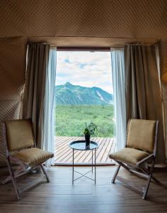 two chairs and a table in front of a window at Sentio Camps - All Inclusive in Cabra Corral
