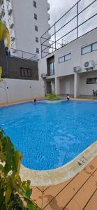 a large blue swimming pool in front of a building at JZA Staycation 1 in Mactan