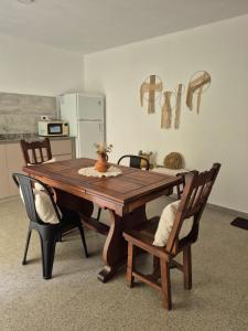 a wooden table in a kitchen with two chairs at CasaMora departamento céntrico con cochera gratis, 2 habitaciones in Almafuerte