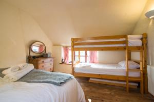 a bedroom with two bunk beds and a mirror at Colourmill cottage in Leek