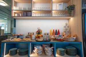 a shelf with plates and other food on it at Hotel B&B Stossplatz anytime and easy self Check-in in Appenzell