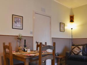 a dining room with a table and a chair at Macdonald Cottage in Balnald