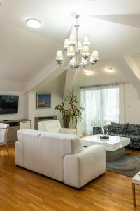 a living room with a white couch and a chandelier at Garni Hotel Nevski in Belgrade