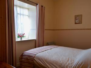 a bedroom with a bed and a window at Macdonald Cottage in Balnald