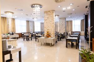 a dining room with tables and chairs and chandeliers at Garni Hotel Nevski in Belgrade