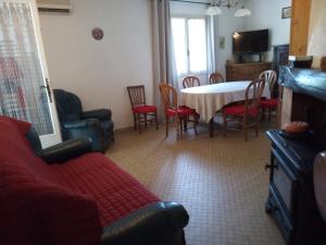 a living room with a red couch and a table and chairs at La simonde in Malarce-sur-la-Thines
