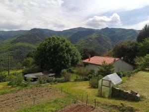 a garden with a house and mountains in the background at La simonde in Malarce-sur-la-Thines