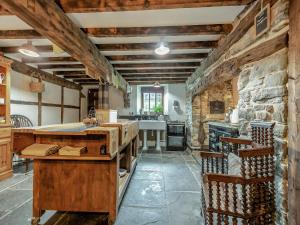 a large kitchen with a stone wall at Ynywsen Dairy Flat in Nantgaredig