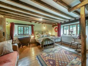 a bedroom with a bed and a couch and windows at Ynywsen Dairy Flat in Nantgaredig