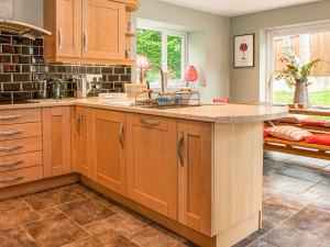 a kitchen with wooden cabinets and a large island at Brooklands in Uplyme +22 photos