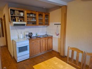 a kitchen with wooden cabinets and a white stove top oven at Simon-Dach-Haus in Klaipėda